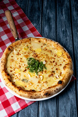 Tasty sliced pizza with fresh arugula and different kinds of cheese. Four cheese pizza, pizza Margarita.