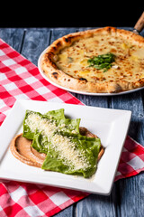 Hot ravioli with spinach served in a white plate with sause, pizza Margarita. Traditional italian cuisine