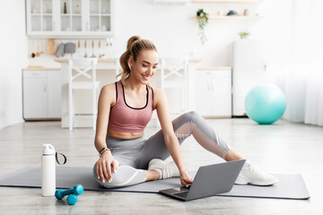 Cheerful caucasian pretty millennial blonde fitness female blogger looking at laptop, coach...