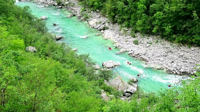 Kayaking on the blue Soča river - Colourful kayaks drifting into the valley