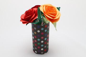 折り紙で作ったバラの花をカラフルなグラスに飾った様子