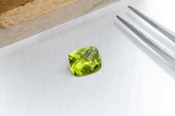 macro mineral faceted stone cut Peridot on a gray background