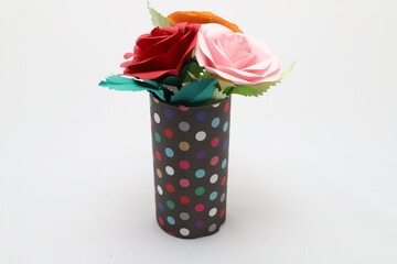 折り紙で作ったバラの花をカラフルなグラスに飾った様子