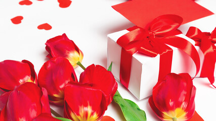 Red tulips, gift box and greeting card with hearts for Valentine's Day