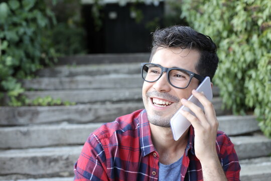 Optimist young man with eyeglasses making a phone call