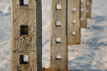 Detail of hayrack pillars in winter side-lit by golden sunlight