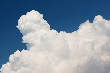 Naklejka na ściany i meble Rising white cumulus clouds in blue sky
