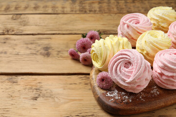 Delicious pink and yellow marshmallows on wooden table. Space for text
