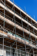 Metal scaffolding building frame with wooden boards platform on an industry construction site, stock photo image