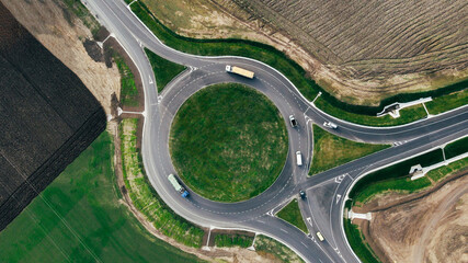 Roundabout traffic of cars and trucks on the circle ring road aerial top view - Powered by Adobe
