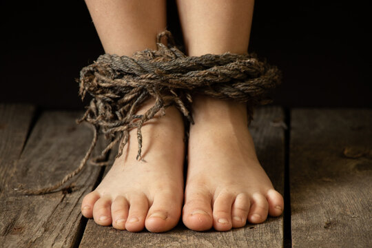 children's feet bound with an old dirty rope, slavery and theft of people