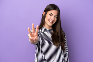 Young Brazilian woman isolated on purple background happy and counting three with fingers