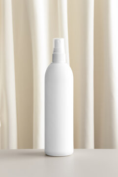White cosmetic spray bottle mockup with a yellow textile.