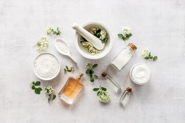 Obraz na płótnie Canvas White medical herbal cosmetics in flowers - with skin cream and bath salt