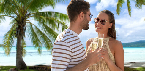 leisure, travel and tourism concept - happy couple in sunglasses drinking champagne over tropical...