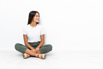 Teenager girl sitting on the floor looking side