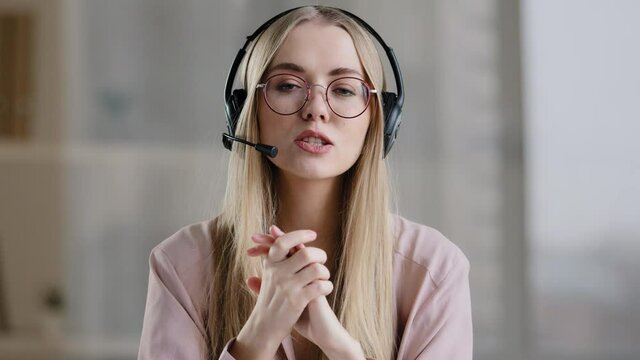 Close-up woman worker manager agent help line consultant girl in head microphone talking advises explaining showing form in air working customer support service operator in headphones with microphone