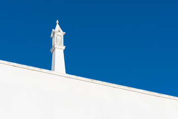 blue sky with a chimney typical of the houses of the Algarve in Portugal.