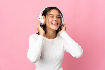 Teenager girl isolated on blue background listening music