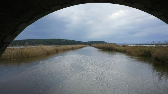 Aerial Reveal of exposed bridge in marshland, Narbonne, France