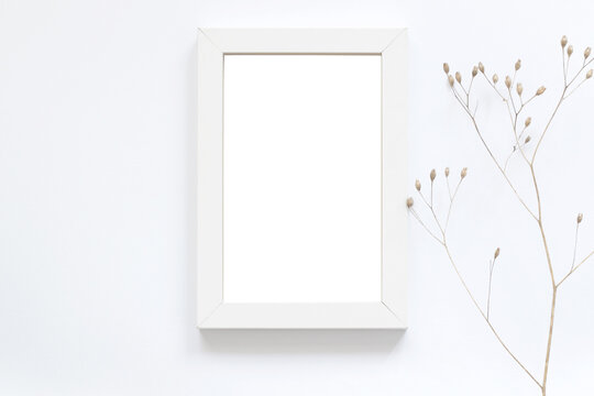blank white photo frame with dry autumn flowers, art mockup