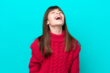 Little caucasian girl isolated on blue background laughing