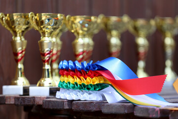  Pile of sport trophies and badges rosettes for the winners on show jumping competition