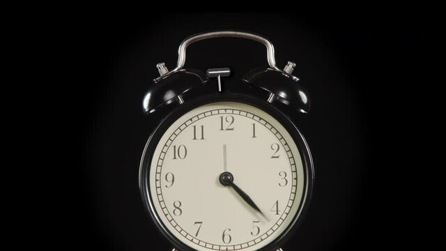 Alarm Clock Time. The hands of a classic alarm clock quickly rotate on the dial, stop abruptly at 12 and the bell mechanism is triggered