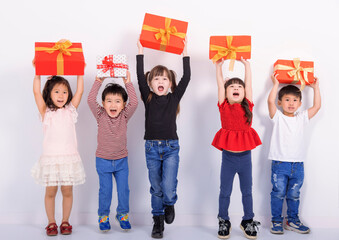 Happy kids celebrating holiday and showing the gift box