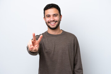 Fototapeta premium Young Brazilian man isolated on white background smiling and showing victory sign