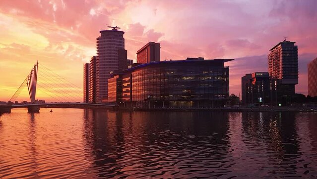 Manchester,01/07/2019: england:establishing shot wide angle view of salford quays waterside mediacityuk district at sunset