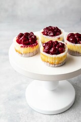 Mini cheesecake with cherry jam. One bite dessert. Tiny cheesecakes with berry. Valentine homemade present. Selective focus.
