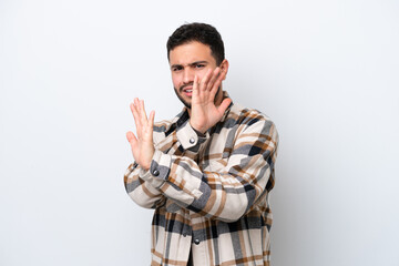 Young Brazilian man isolated on white background nervous stretching hands to the front