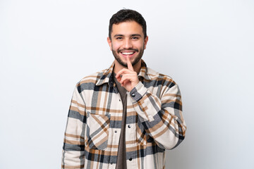 Young Brazilian man isolated on white background showing a sign of silence gesture putting finger in mouth