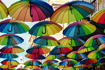 Fototapeta na wymiar umbrellas hanging in a street in lisbon painted with the gay pride flag.