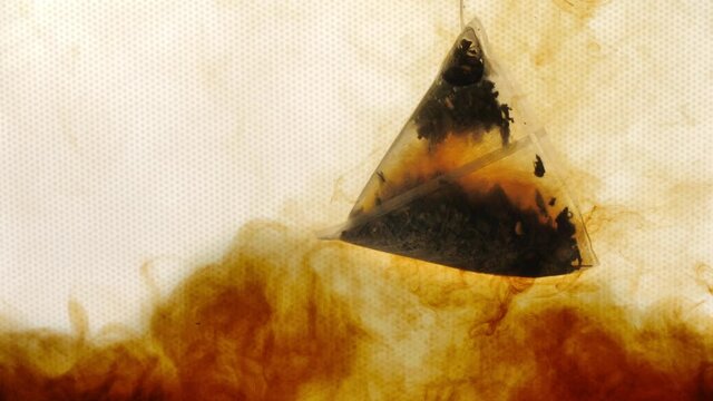 Black Tea Bag Dipped in Hot Water Underwater Close-Up