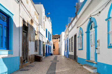 white and blue houses typical of the fishing village of Olhao, Algarve, Portugal.