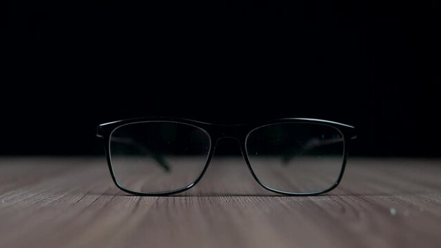 Isolated work eyeglasses on a desk. Black, formal, business spectacles for office, computer or reading. Eye problems, blurred vision, myopia, near-sightedness, short-sightedness. Eyesight checking.
