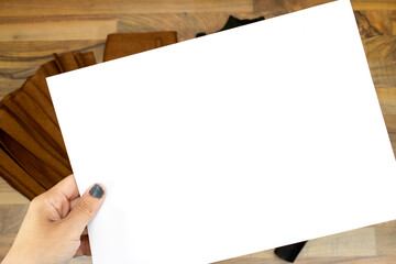 closeup woman hands holding a blank papers, billboard. top view