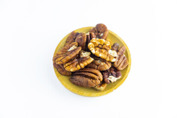 Fototapeta na wymiar Pecan nuts in wooden plate isolated on white background