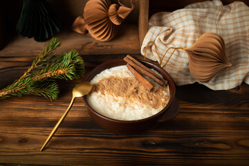 Delicious rice pudding with cinnamon in bowl on wooden background