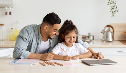 Loving single father and daughter painting together, kitchen interior