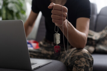 patriotic military man in headset looking at laptop near american flag