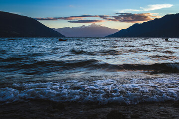Waves reaching the coast and the mountain in the background