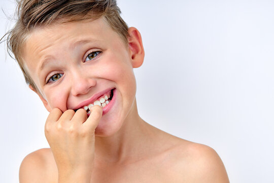 child boy touching teeth, checking the cleanliness, looking at mirror. isolated on white studio background, portrait. shirtless caucasian kid having perfect teeth, smile. children, health concept