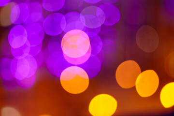 Rose-gold bokeh on a lilac-yellow background. Glittering lights are not in sharpness.