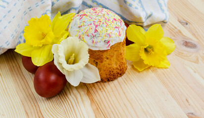 Obraz na płótnie Canvas Easter table setting in a traditional Ukrainian house. Easter cake with sprinkling, colored eggs and fresh spring flowers