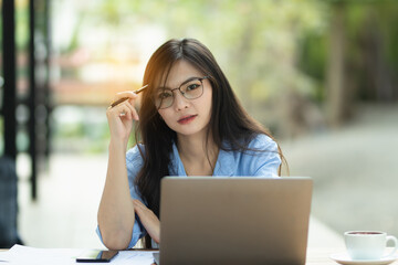 Asia Woman is working on the personal computer and smartphone at the internet work from home