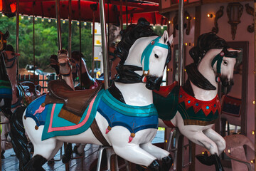 Fototapeta na wymiar Two white carousel horses with black manes 