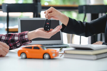 Insurance officers hand over the car keys after the tenant. have signed an auto insurance document or a lease or agreement document Buying or selling a new or used car with a car